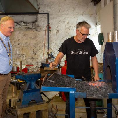 The Mayor watches sculptor Ned Jackson Smyth at work during a visit to his studio.