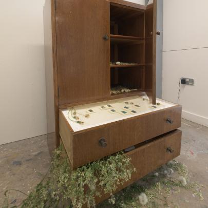 a wooden cabinet with flower installations
