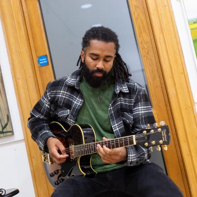 a guitarist is playing in a gallery