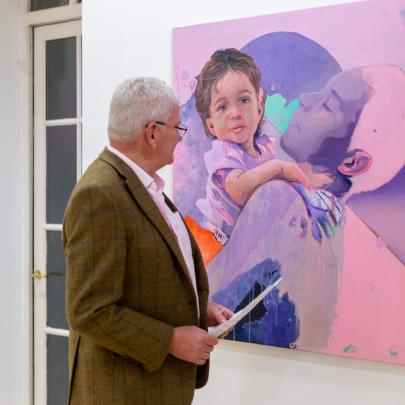 A man views a large painting in a gallery