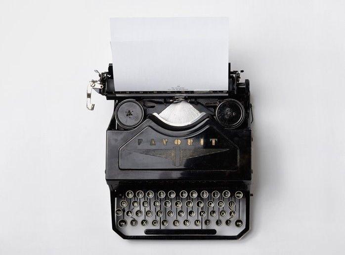 Typewriter on a plain white desk